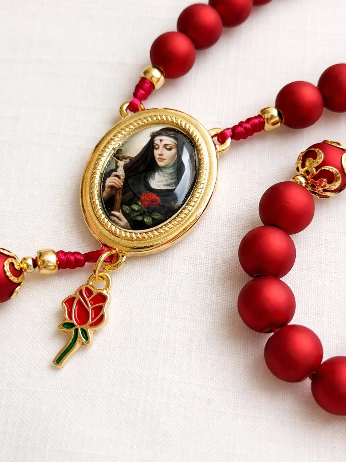Detalhe do entremeio de Santa Rita de Cássia com rosa e strass